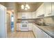 Efficient kitchen with white cabinets, updated appliances, and a modern faucet at 5058 Cimarron Dr, Lakeland, FL 33813