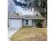 Gray house with a white door, landscaped yard, and attached garage at 520 Green Cir, Fort Meade, FL 33841