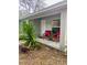 Covered porch with two red chairs and potted plants at 520 Green Cir, Fort Meade, FL 33841