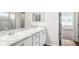 Bright bathroom featuring dual sinks with a marble countertop, framed mirror, and doorway to bedroom at 565 Sw 77Th Cir, Ocala, FL 34474