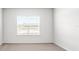 Bright bedroom with large window, neutral carpeting, white walls, and natural light at 565 Sw 77Th Cir, Ocala, FL 34474