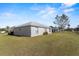 Rear exterior view of the house, showcasing well-maintained lawn and partial fencing at 8183 Westmont Terrace Dr, Lakeland, FL 33810