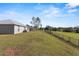 View of the backyard, showcasing a sloped lawn and a fence at 8183 Westmont Terrace Dr, Lakeland, FL 33810