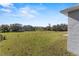 Fenced backyard with a spacious grassy area and views of a green field and trees at 8183 Westmont Terrace Dr, Lakeland, FL 33810