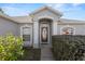 Charming home exterior featuring a decorative front door, manicured landscaping, and architectural details at 8183 Westmont Terrace Dr, Lakeland, FL 33810