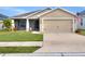 Tan one-story house with a two-car garage and nicely landscaped lawn at 1034 Corso Dr, Winter Haven, FL 33884