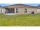 Tan house exterior with a screened porch and backyard at 1034 Corso Dr, Winter Haven, FL 33884