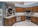Kitchen boasts stainless steel appliances, wood cabinets, and ample counter space at 111 Arbor Way, Auburndale, FL 33823