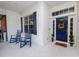 Front porch with blue door and rocking chairs at 1520 Royal Forest Loop, Lakeland, FL 33811