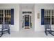 Front porch with blue door and rocking chairs at 1520 Royal Forest Loop, Lakeland, FL 33811