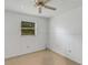 Bedroom with ceiling fan, window, and wood paneling at 1704 Pineberry Ct, Lakeland, FL 33803