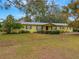 Ranch style home with green exterior, landscaping, and spacious yard at 1704 Pineberry Ct, Lakeland, FL 33803