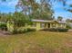 Ranch style home with a light green exterior, landscaping, and a spacious yard at 1704 Pineberry Ct, Lakeland, FL 33803