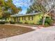 Green Ranch home with walkway, landscaping, and driveway at 1704 Pineberry Ct, Lakeland, FL 33803