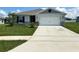 Gray house with white garage door and green lawn at 2300 Crossandra St, Mascotte, FL 34753