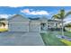 Two-car garage, gray siding, and a welcoming front porch at 241 Walkers Point Dr, Auburndale, FL 33823