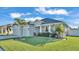 Newly built home with two-car garage, landscaping, and palm trees at 241 Walkers Point Dr, Auburndale, FL 33823