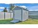 Gray storage shed with white roll-up door and small window at 241 Walkers Point Dr, Auburndale, FL 33823