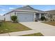 Single-story house with gray siding, two-car garage, and landscaping at 416 Monticelli Dr, Haines City, FL 33844