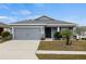 Gray house with two-car garage and landscaped front yard at 416 Monticelli Dr, Haines City, FL 33844