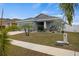 Single story home with gray siding, two-car garage, and nicely landscaped yard at 416 Monticelli Dr, Haines City, FL 33844