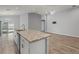Open kitchen boasts an island, stainless steel appliances, and wood-look flooring at 416 Monticelli Dr, Haines City, FL 33844