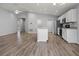 Open kitchen with island, stainless steel appliances, and wood-look flooring at 416 Monticelli Dr, Haines City, FL 33844