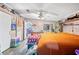 Main bedroom with an orange comforter, ceiling fan, and built-in shelving at 4307 Meadow Ridge Ct, Mulberry, FL 33860