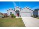 Gray house with red door, two-car garage, and landscaped lawn at 4340 Reding Way, Lakeland, FL 33813