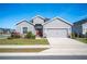 Gray house with red door, two-car garage, and landscaped lawn at 4340 Reding Way, Lakeland, FL 33813