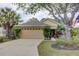 Tan house with a two-car garage and lush landscaping at 731 Lake Clark Ct, Lakeland, FL 33813