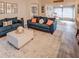 Open living room with two sofas, ottoman and view into sunroom at 731 Lake Clark Ct, Lakeland, FL 33813