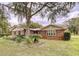 Brick ranch house with a large yard and shade trees at 7405 Havenwood Dr, Lakeland, FL 33810