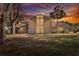 Two-story house with a large yard, mature trees, and a sunset backdrop at 1118 Cypress W Pt, Winter Haven, FL 33884