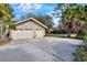 Two-car garage with spacious driveway and mature landscaping at 1118 Cypress W Pt, Winter Haven, FL 33884