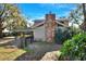Back of house with stone chimney, screened porch and fenced yard at 1118 Cypress W Pt, Winter Haven, FL 33884