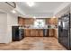 Kitchen features wood cabinets, stainless steel appliances, and wood floors at 1118 Cypress W Pt, Winter Haven, FL 33884