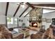 Living room with a stone fireplace, exposed beams and hardwood floors at 1118 Cypress W Pt, Winter Haven, FL 33884