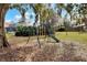 A swing set with a slide in a grassy backyard at 1118 Cypress W Pt, Winter Haven, FL 33884