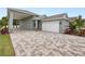 Green house with white garage door, paver driveway, and covered porch at 161 Laynewade Rd, Polk City, FL 33868