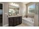 Bathroom boasts a soaking tub, vanity with granite countertop, and large mirror at 252 Magneta Loop, Auburndale, FL 33823