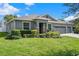 Charming single-story home featuring a three-car garage, manicured lawn, stone accents, and inviting entryway at 252 Magneta Loop, Auburndale, FL 33823