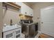 An efficient laundry room with stainless steel appliances, white cabinets, and a sink at 252 Magneta Loop, Auburndale, FL 33823