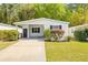 White single-wide manufactured home with carport, landscaping, and paved driveway at 32334 Oak Park Dr, Leesburg, FL 34748