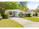 White single-wide manufactured home with carport and landscaping at 32334 Oak Park Dr, Leesburg, FL 34748