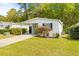 Front view of a white single-wide manufactured home with carport and landscaping at 32334 Oak Park Dr, Leesburg, FL 34748