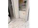 Well-lit laundry room with washer, dryer, and storage shelves at 32334 Oak Park Dr, Leesburg, FL 34748