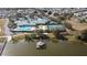Aerial view of the Traditions community clubhouse with lake access, a dock and waterside gazebo at 3441 Grenville Dr, Winter Haven, FL 33884