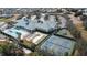 Aerial view of the Traditions community clubhouse, pool, and tennis courts surrounded by lush landscaping at 3441 Grenville Dr, Winter Haven, FL 33884