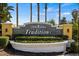 Traditions community sign with manicured landscaping and palm trees welcomes residents and visitors alike at 3441 Grenville Dr, Winter Haven, FL 33884